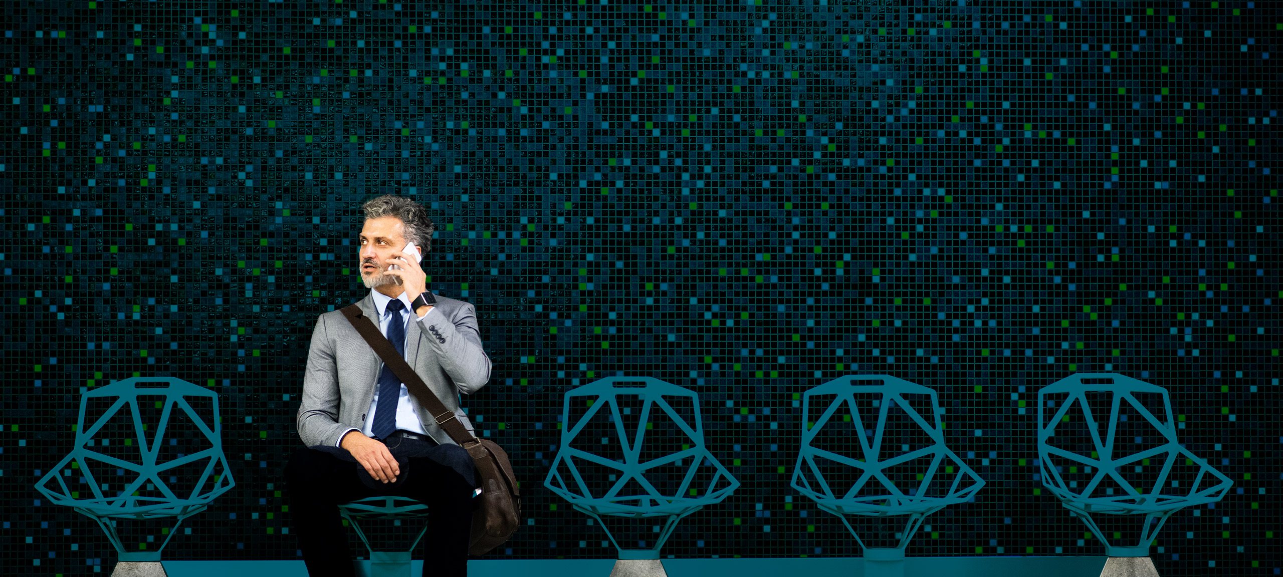 Ein Mann sitzt auf einem Stuhl und telefoniert